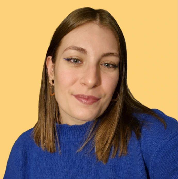 Portrait de Marine, fond uni jaune, portant un pull bleu vif et souriant légèrement